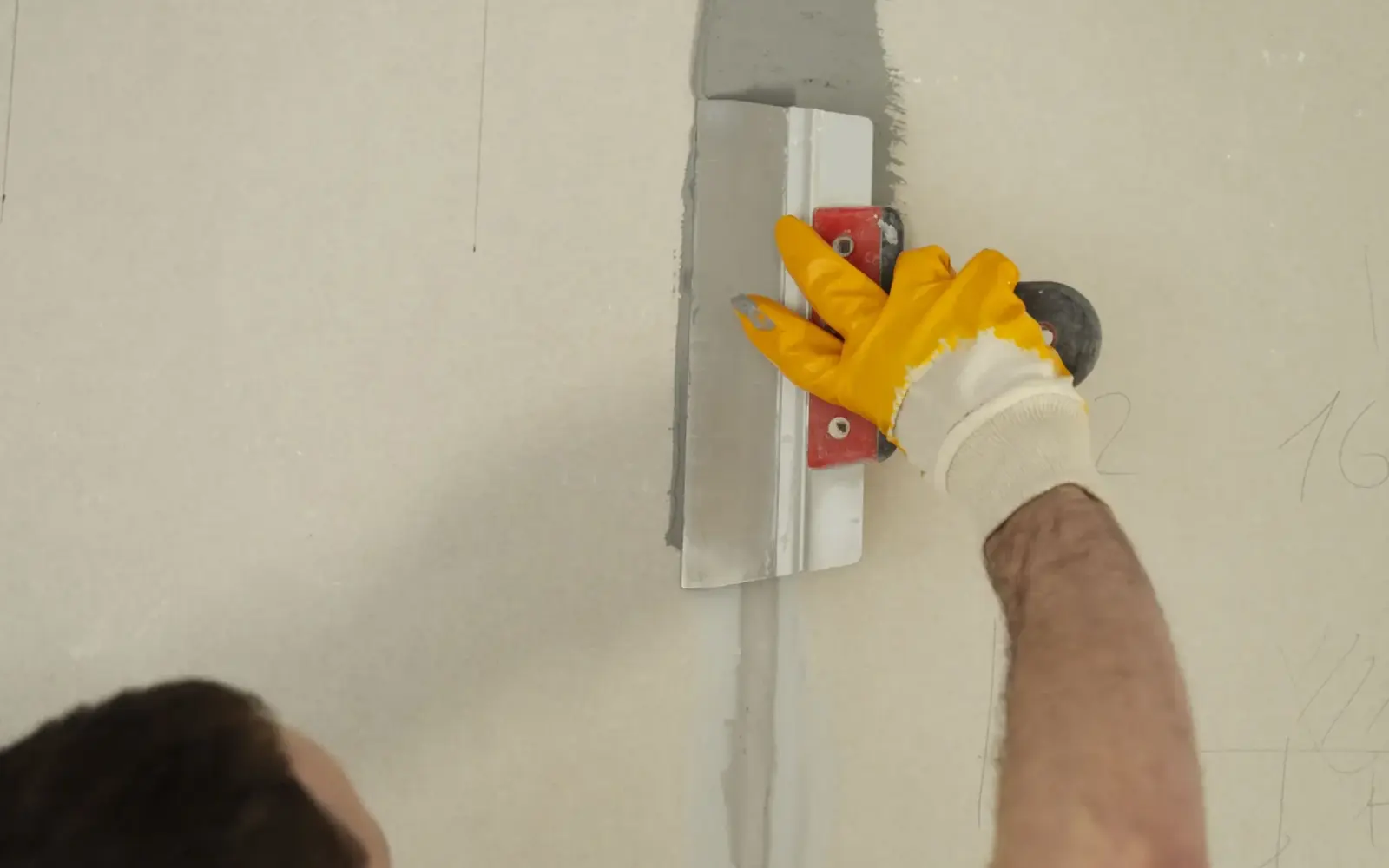 Technician applying plaster to prepare an interior wall